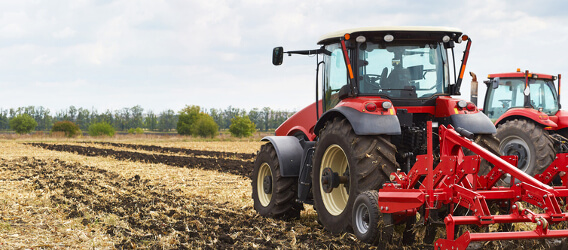 Un tractor labrando la tierra. Carburantes y servicios para empresas